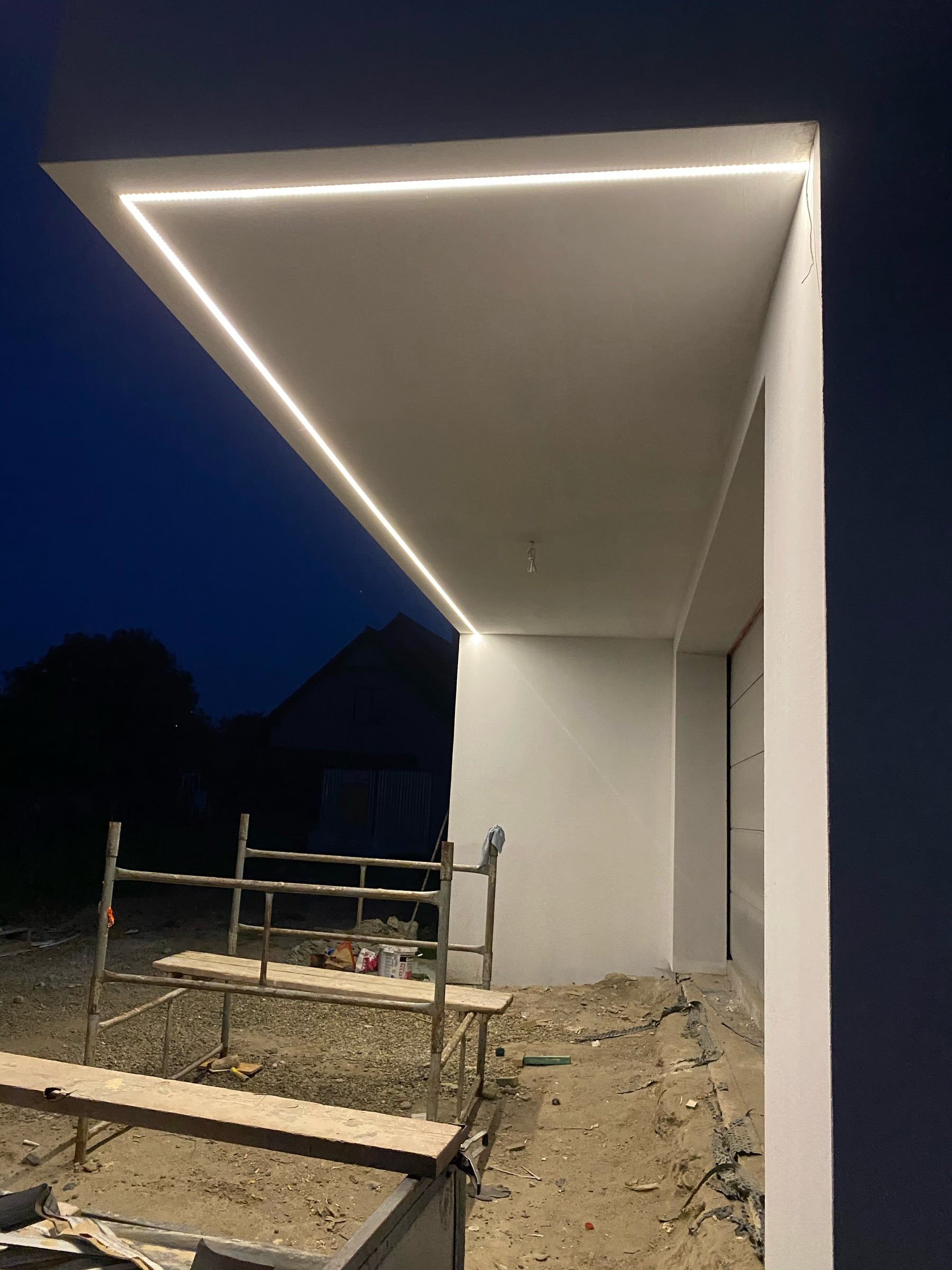 Linia świetlna LED w podsufitce portalu nad wjazdem do garażu nocą