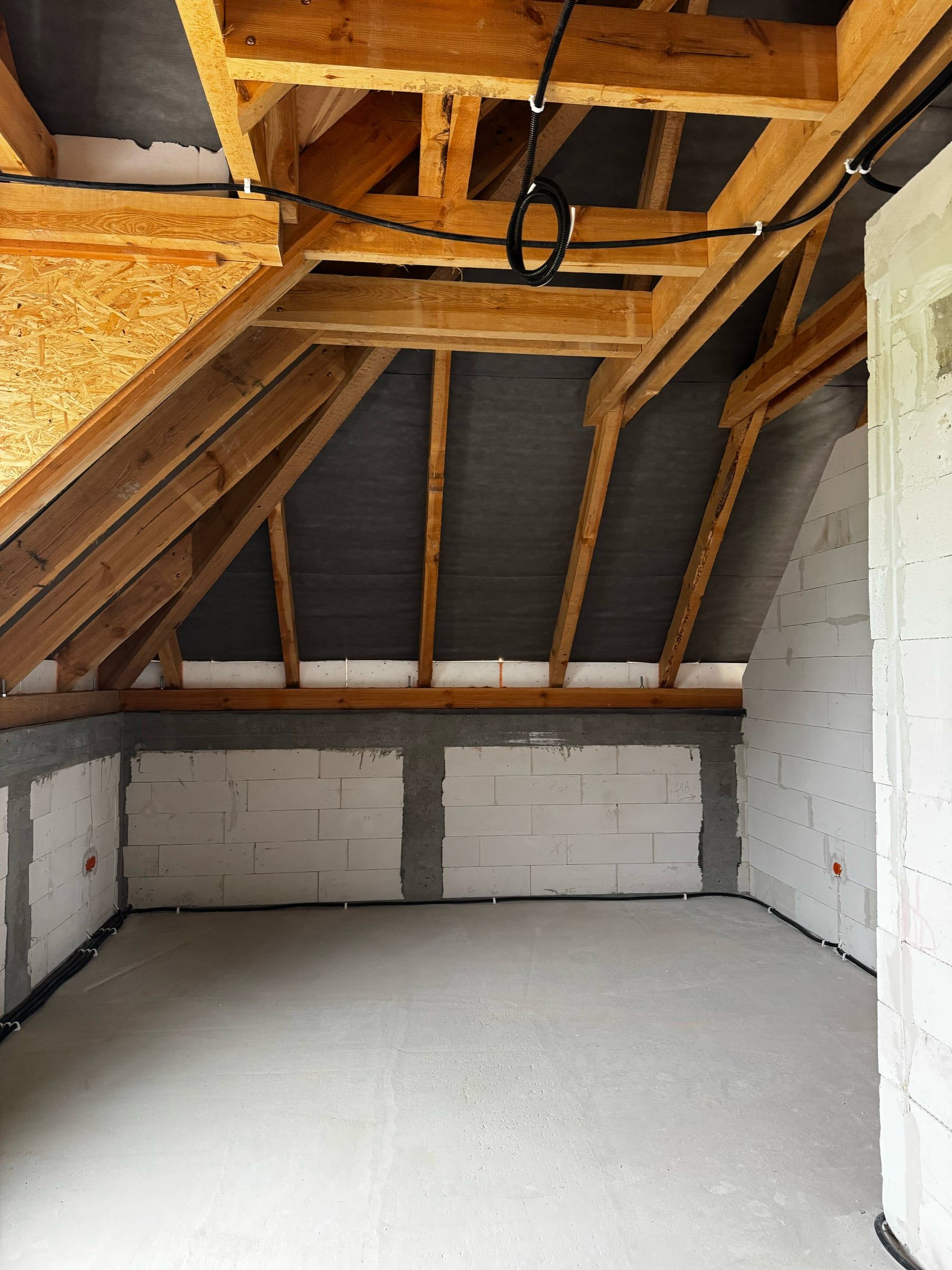 Poddasze pod drewnianą więźbą z przewodami pod jętkami i puszkami na ściance kolankowej